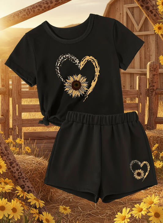 A two-piece outfit set for girls featuring a black top with a leopard print design and a heart graphic, paired with matching shorts, displayed with accessories such as sunglasses and sandals.